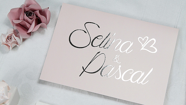 Einladungskarte mit rosaschimmerndem Papier und einer Heissfolienpraegung in der Farbe silber. 